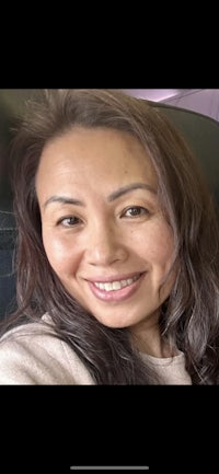 a woman is smiling while sitting on an airplane
