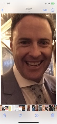 a man in a suit and tie is smiling at the camera